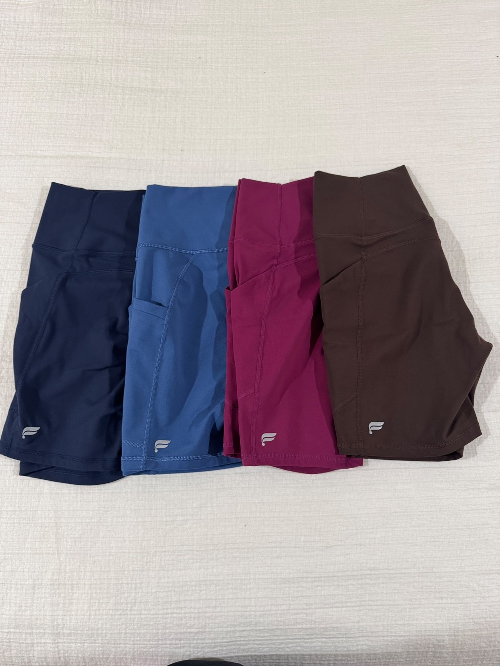 Fabletics Women's High-Rise Bike Shorts Trio - Navy, Blue, Berry, Brown